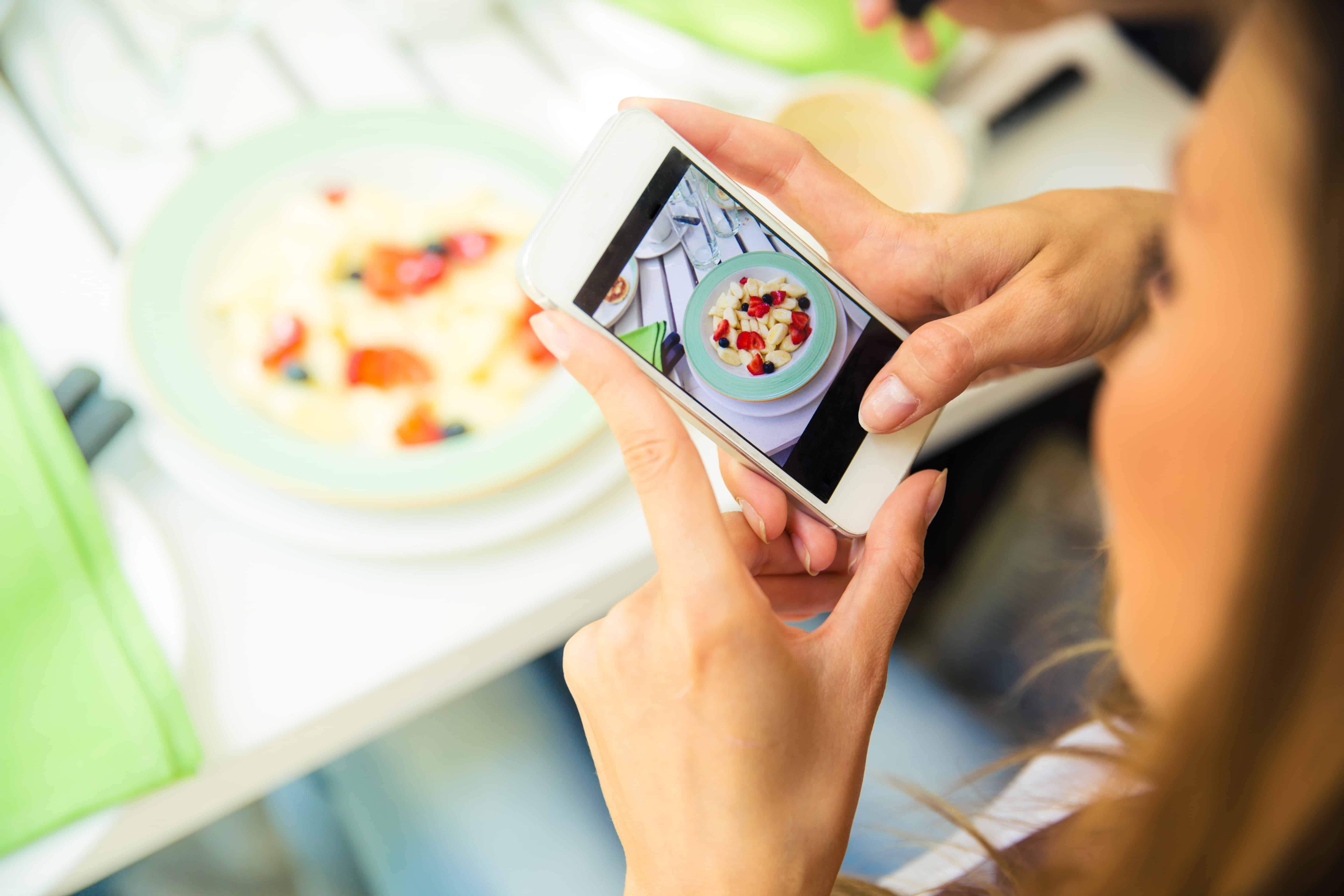 Woman making photo of food on smartphone