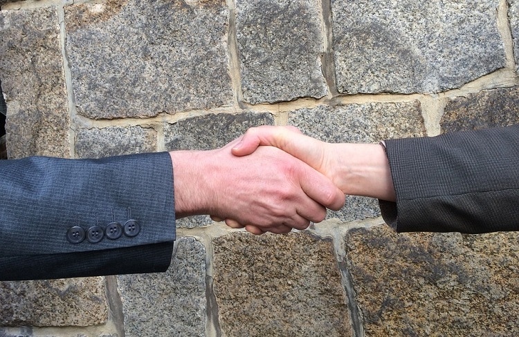People shaking hands outside, after a successful negotiation