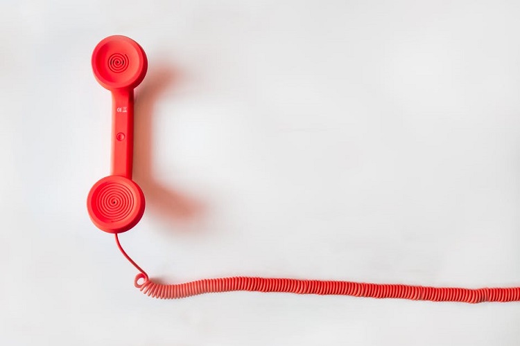 Red phone handset on a white surface