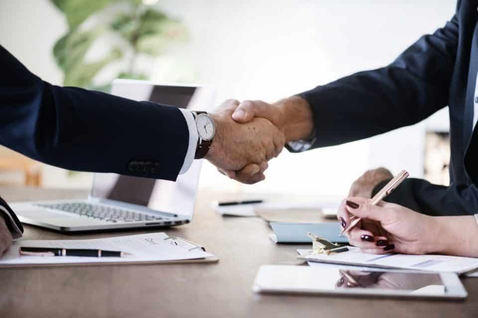 People shaking hands in office - Business collaboration on deal